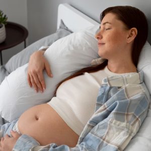 pregnant woman hugging bolster resting