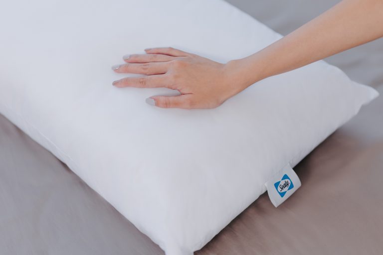 hand touching Sealy Hybrid Memory Foam Pillow