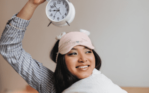 woman smiling holding on to a clock