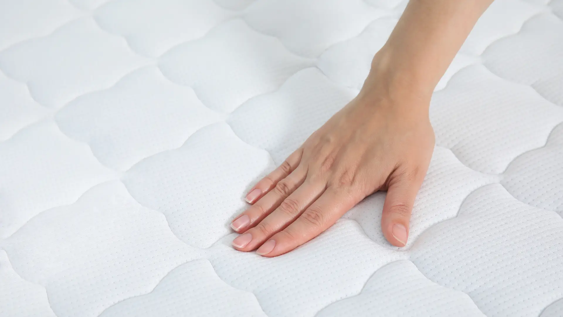 Hand on surface of mattress