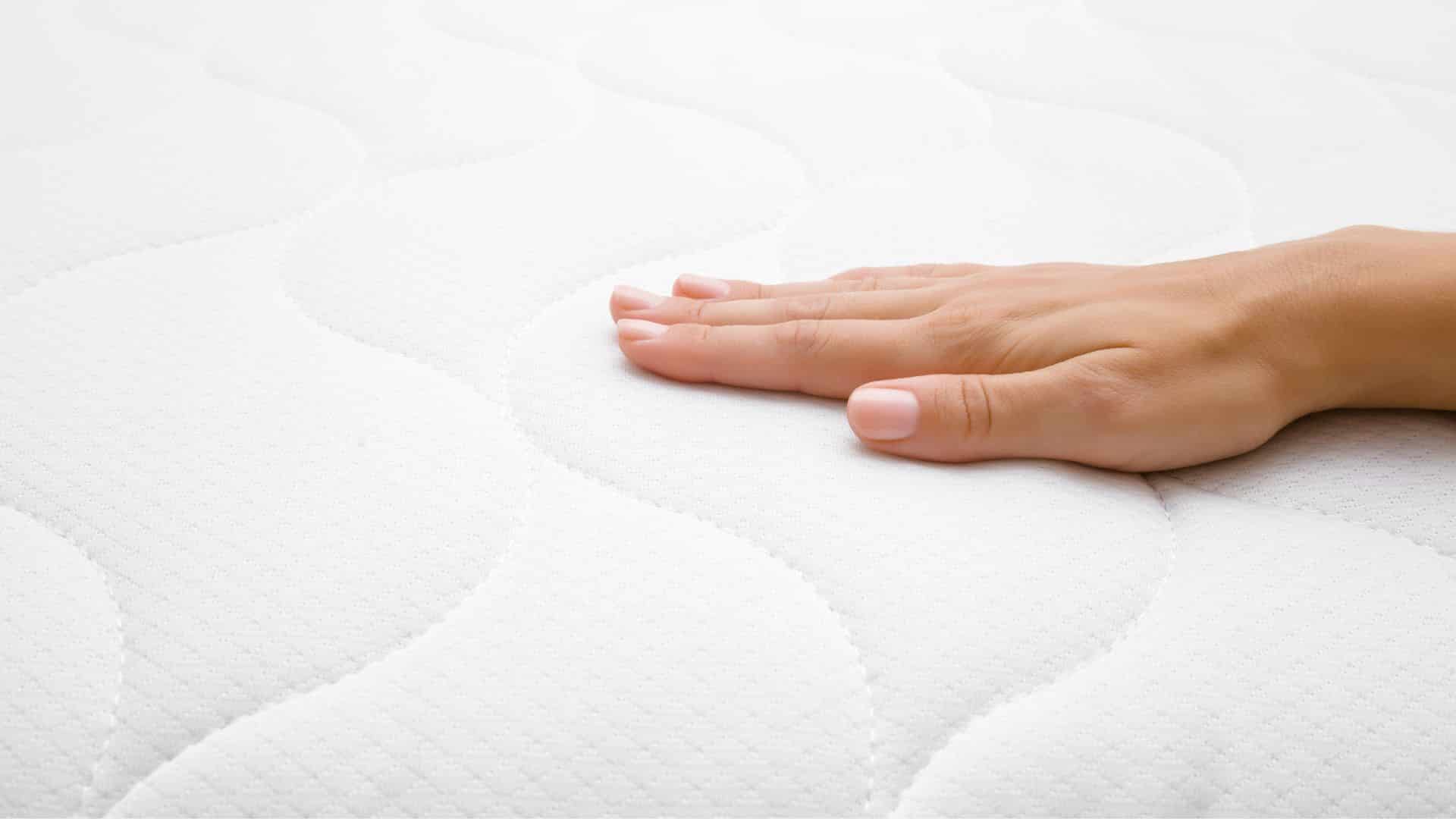 Mattress lifespan, hand on mattress fabric