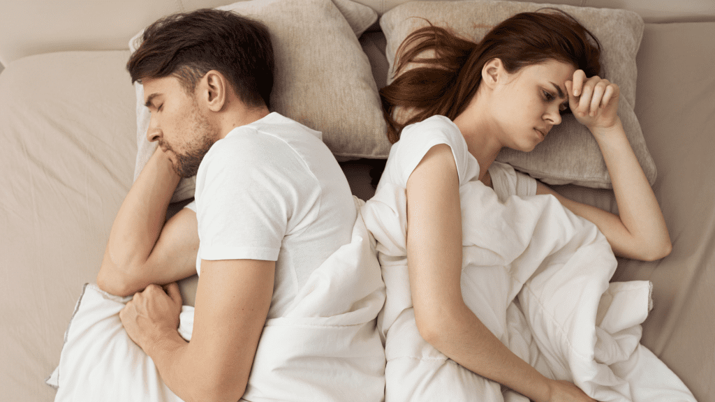 One partner struggling to sleep while the other partner sleeping soundly.