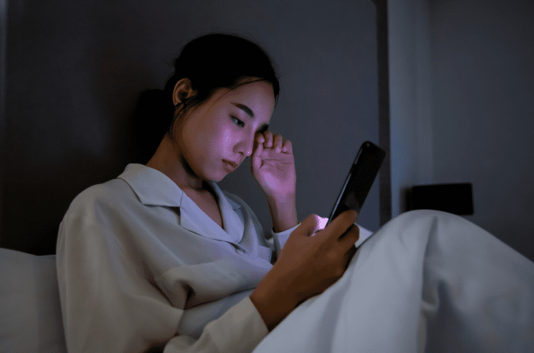 woman with phone on bed