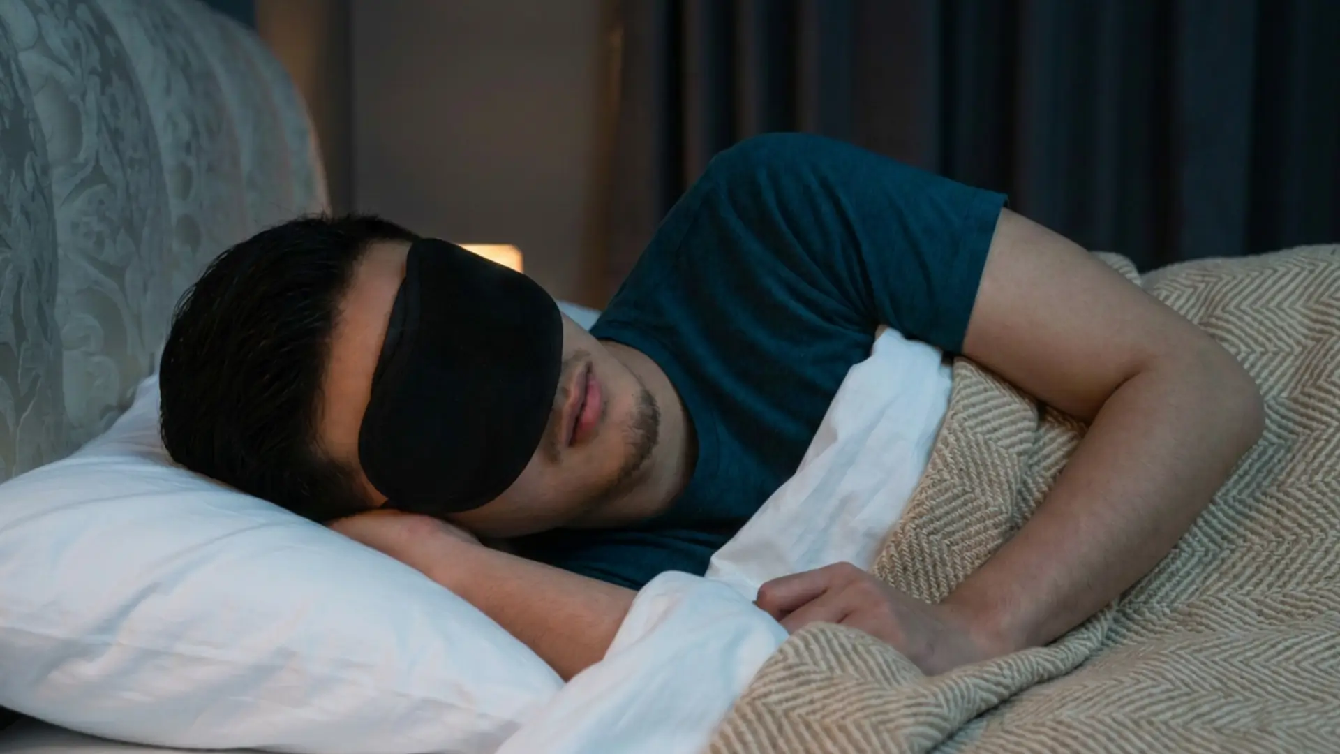 Man wearing an eye mask in bed