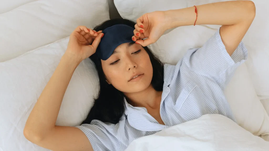 Woman in bed with an eye mask