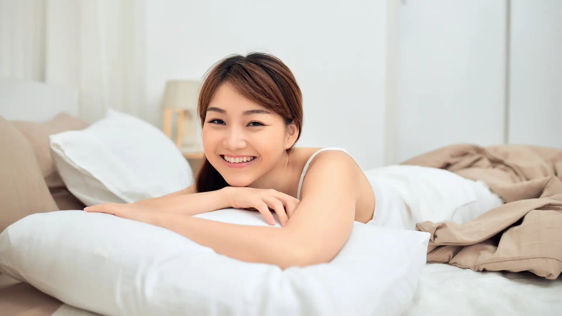Woman lying on bed with pillows