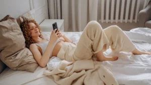 Woman lying in bed on phone