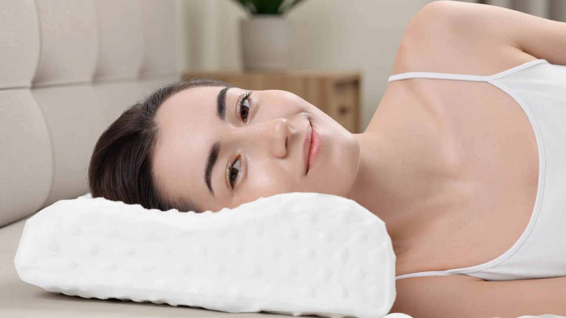 Woman lying on contour pillow